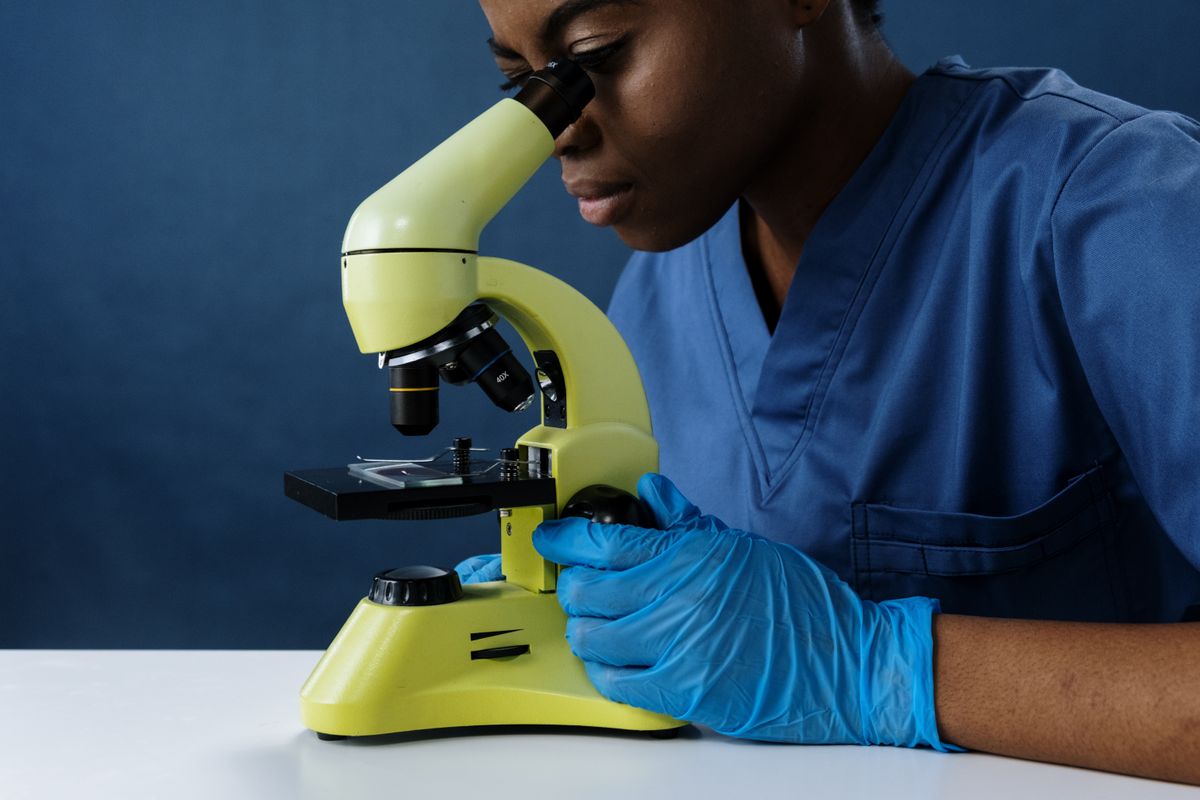 Scientist examining a laboratory sample through a microscope